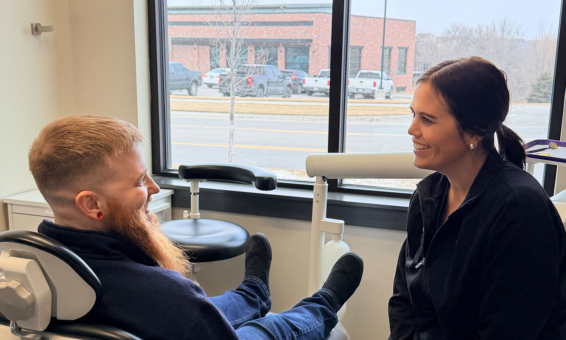 A well-lit reception area with a desk, computer monitor, and potted plant.